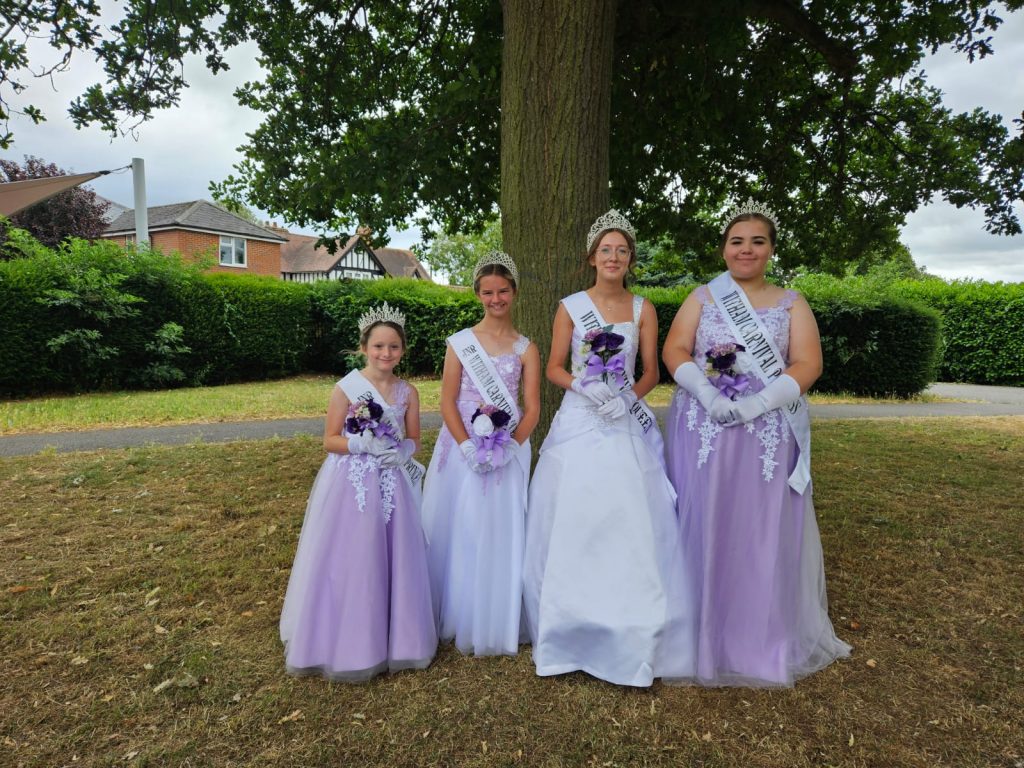 Four girls in front of tree wearing formal dresses